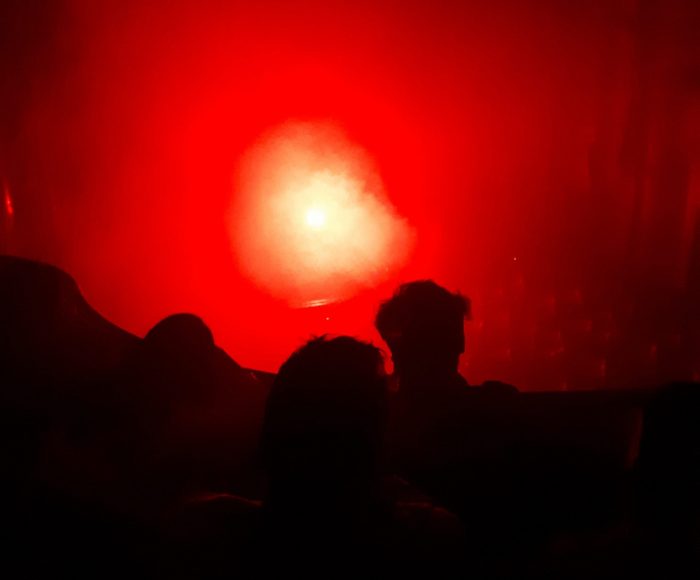 abstract shadow shapes against a bright red background
