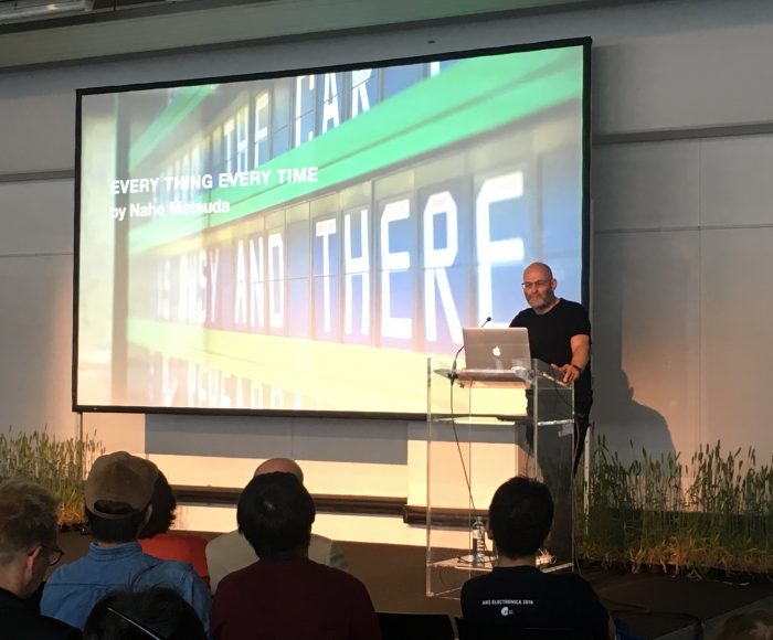 Jason Crouch presents on stage to a room full of people at Ars Electronica