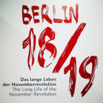 The words Berlin 18/19 are printed in red on a white background. Below typed in black font is: The Long Life of the November Revolution