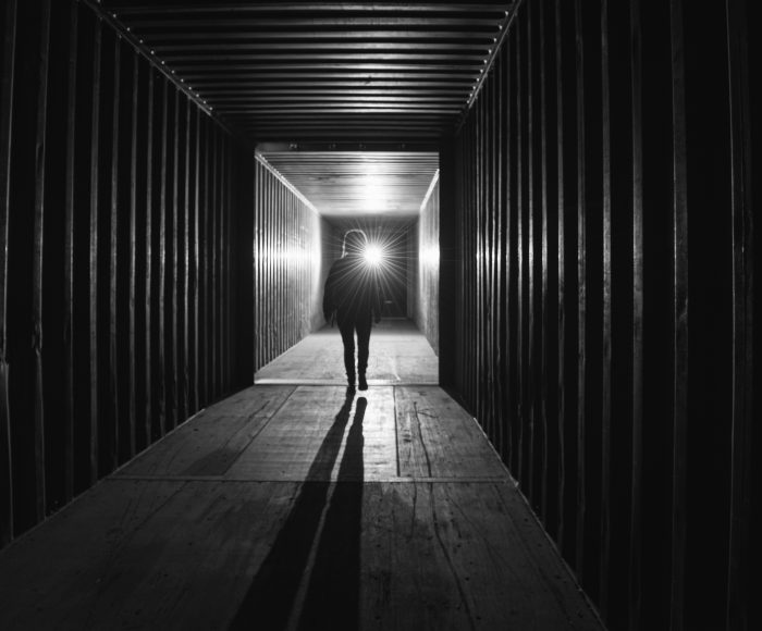 woman walking into dark tunnel